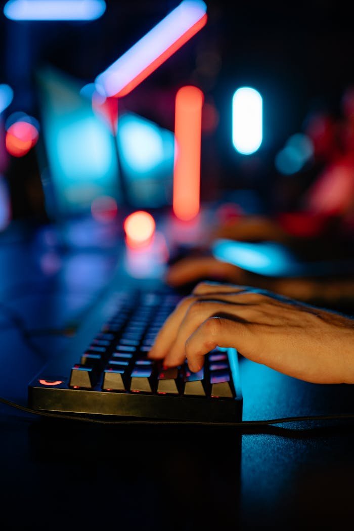 A vibrant image showing a gamer's hands on a keyboard in a neon-lit gaming room, creating a tech-savvy ambiance.